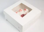 "Exquisite white paper cake box with a glimpse of a sumptuous strawberry cake inside, presented by www.jcpackaging.net"