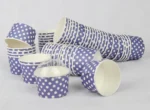 "A medium-sized ice cream cup adorned with white polka dots on a navy blue background, featuring a transparent dome lid, from www.jcpackaging.net."