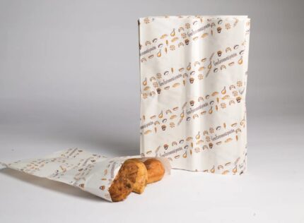 "JC Packaging's greaseproof bags with fun food prints, perfectly holding fresh pastries, highlighting mess-free, durable design."