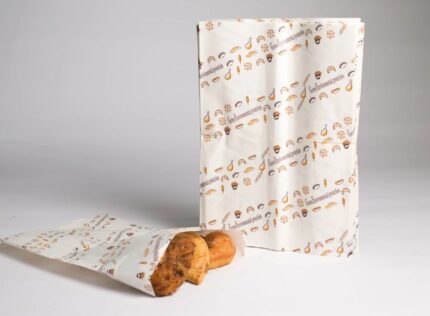 JC Packaging's greaseproof bags with fun food prints, perfectly holding fresh pastries, highlighting mess-free, durable design.