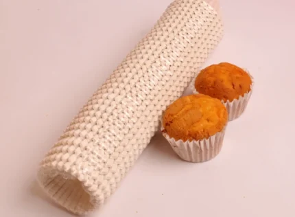 "Two golden-baked muffins in white muffin cups beside a pack of 1000 Jacobs muffin cups, from www.jcpackaging.net."