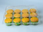 "Clear packaging displaying a dozen golden-baked muffins by JC Packaging, perfect for showcasing bakery products."