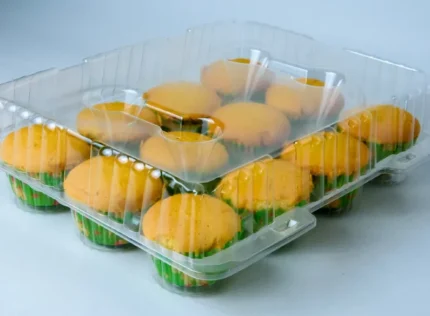 "Transparent pack showcasing a dozen muffins with vibrant green liners, a testament to JC Packaging's commitment to quality presentation."