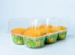 "Side view of JC Packaging's six-muffin display case filled with vibrant yellow muffins in a festive green paper liner, designed for visual appeal and product freshness."