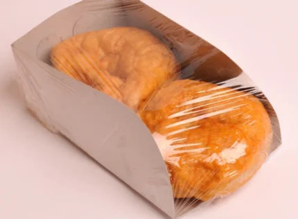 "Two freshly baked pastries in a paper scoop container, showcasing eco-friendly packaging solutions from www.jcpackaging.net."