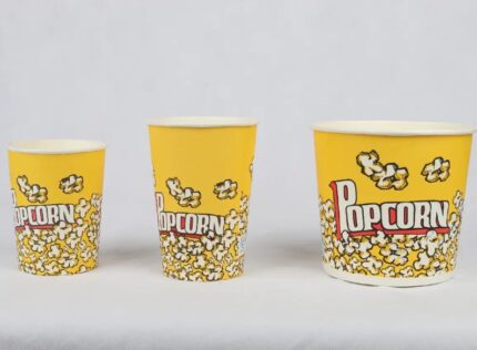 A lineup of three yellow popcorn buckets with the 'Popcorn' logo, from smallest to largest, from www.jcpackaging.net."
