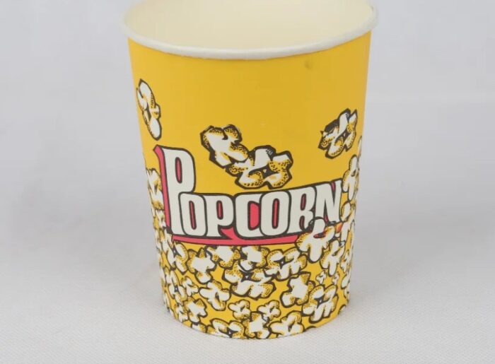"A single 32oz yellow popcorn bucket with a delightful popcorn pattern, available at www.jcpackaging.net."