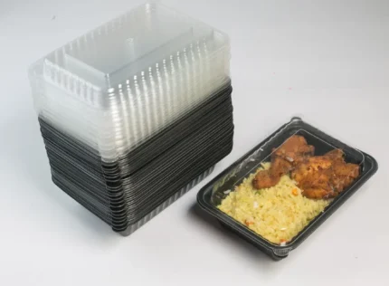 "JC Packaging's single compartment meal box, showcasing a stack of clear-lidded black containers beside a served box with rice and grilled chicken, perfect for convenient meal packaging."