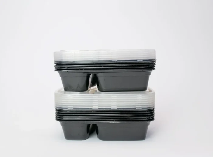 "Stacked 2-compartment plastic plates with clear lids from www.jcpackaging.net"